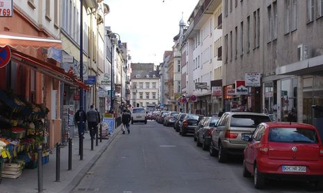 Wellritzstraße mit Häusern und geparkten Autos.