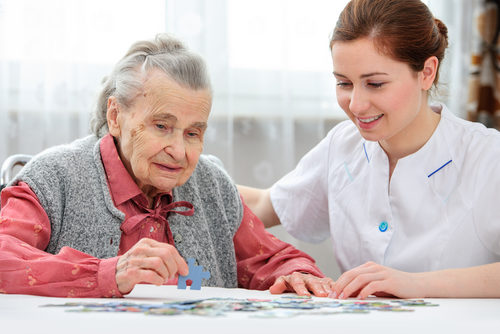 Pflegerin puzzelt mit älterer Frau