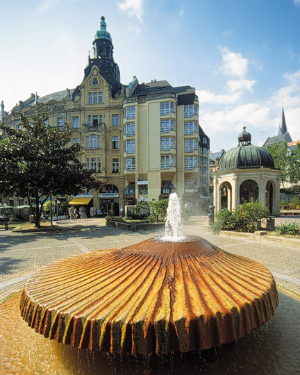 Kranzplatz meydanında fıskiye ve arka planda Kochbrunnen şadırvanı.