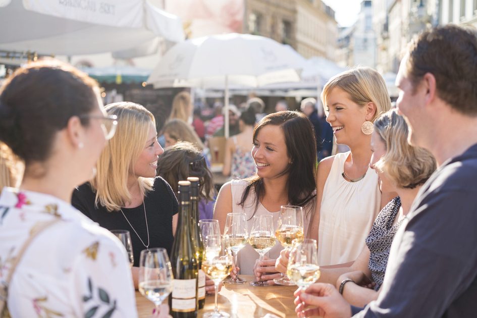 Gruppe junger Menschen um Tisch mit Gläsern
