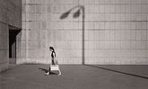 Fotografie: Frau vor gemauerter Wand mit Tasche