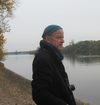Mann mit Mütze und Kamera am Rhein stehend