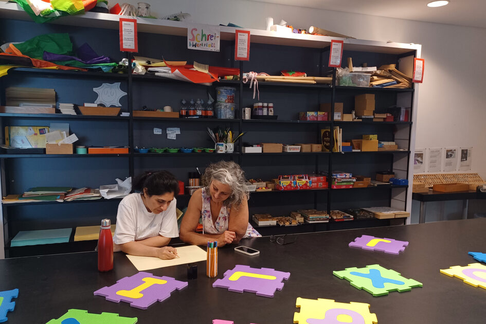 Un professionnel aide une participante à apprendre à une table.