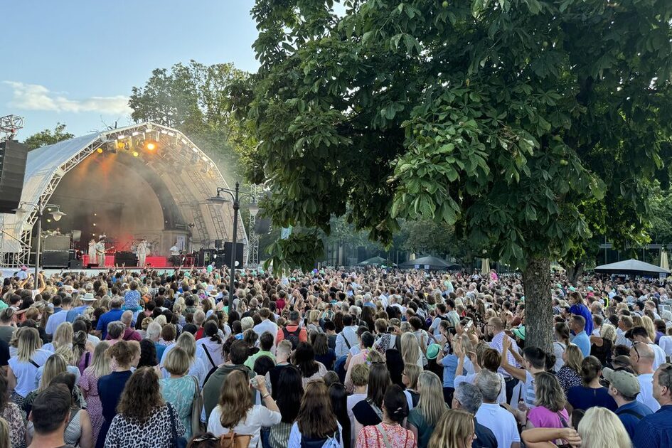 Festival mit vielen Menschen draußen vor einer Bühne stehend
