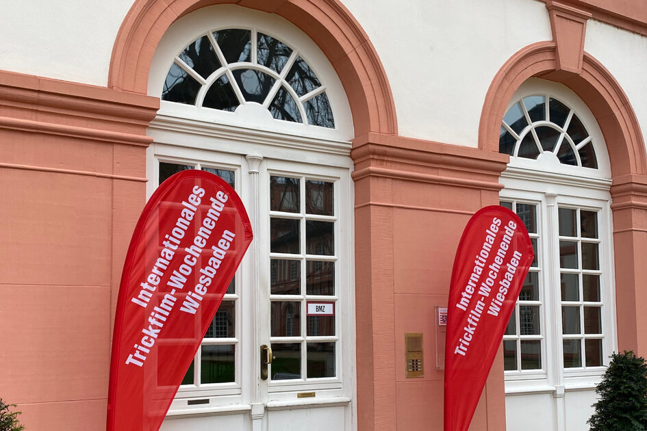 Zwei Fahnen mit der Aufschrift "Internationales Trickfilm-Wochenende Wiesbaden" vor dem Schloss Biebrich