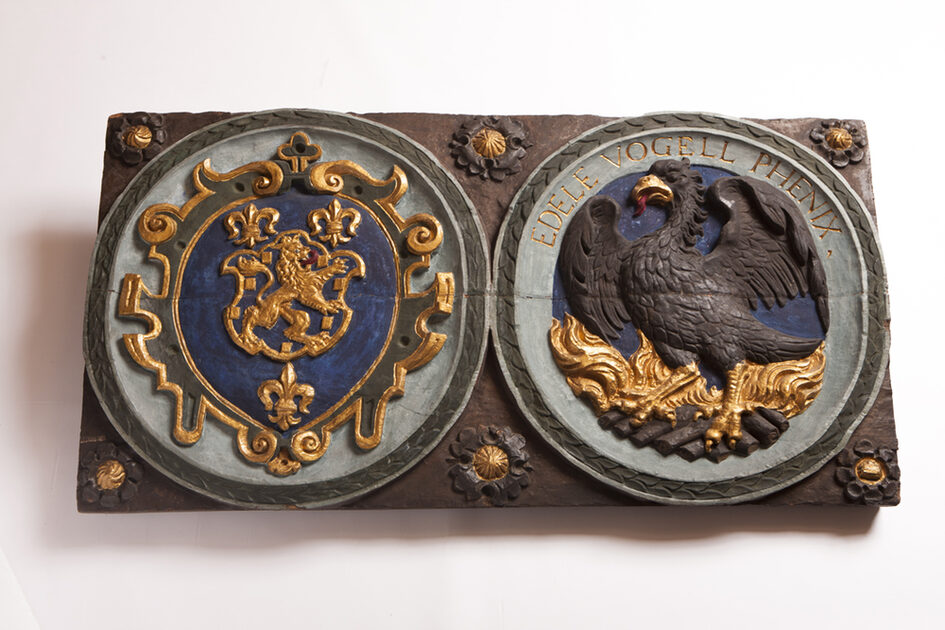 Hölzerne Wappentafel mit Phönix-Darstellung