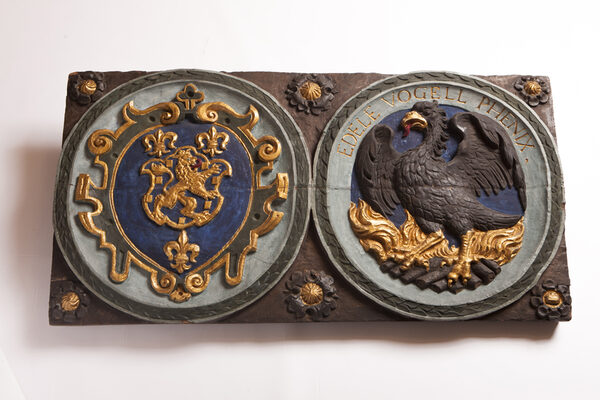 Hölzerne Wappentafel mit Phönix-Darstellung