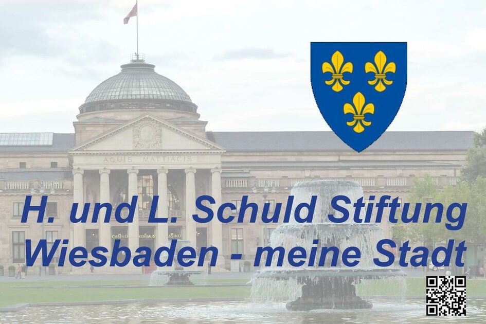 Das Logo der Schuld-Stiftung vor der Ansicht des Wiesbadener Kurhauses