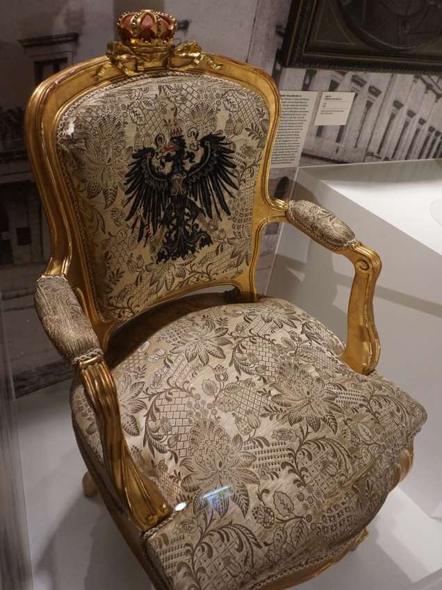 Gepolsterter Sessel mit Reichsadler auf Rückenlehne und Krone auf oberem Rand der Lehne