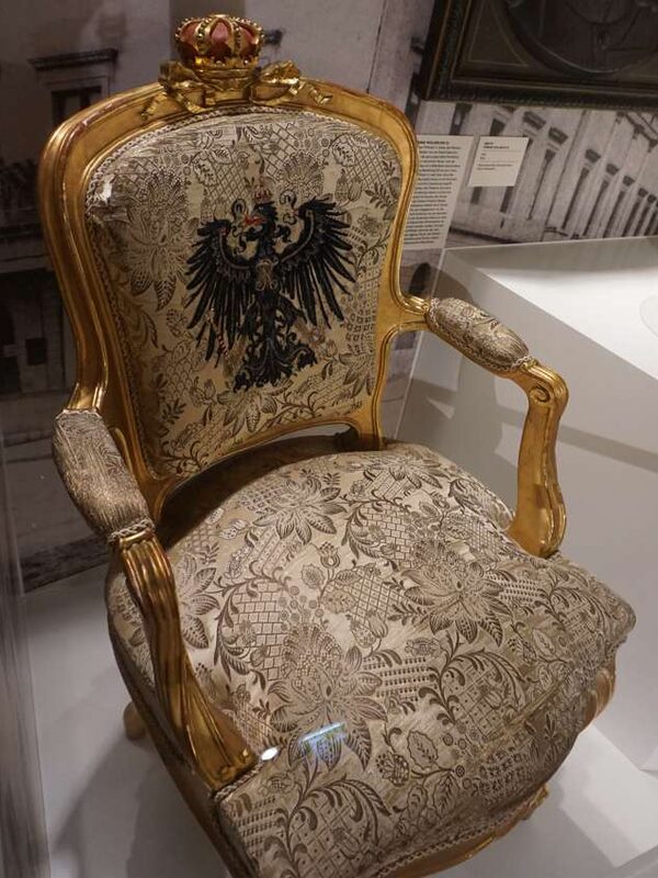 Gepolsterter Sessel mit Reichsadler auf Rückenlehne und Krone auf oberem Rand der Lehne