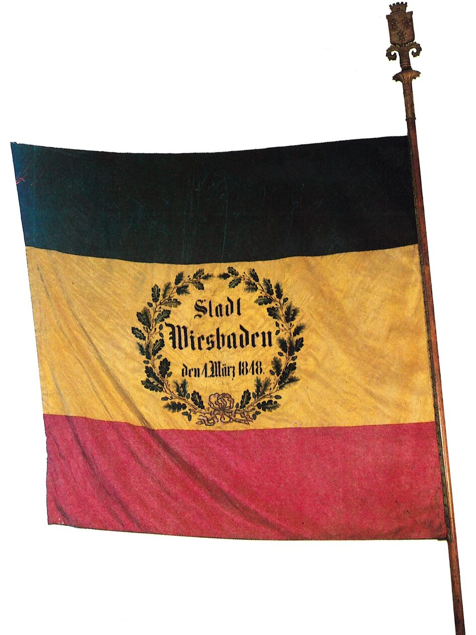 Fahne in schwarz, gold und rot mit Schriftzug Stadt Wiesbaden im März 1848