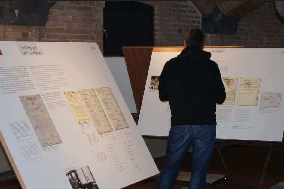 Ziyaretçiler sergideki bir metin panelinin önünde