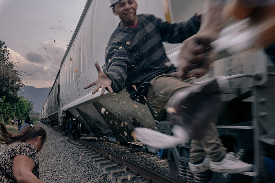 Преминаващ влак с хора, пътуващи отвън