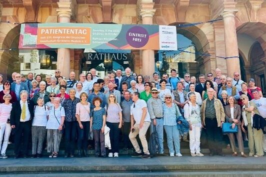 Μια μεγάλη ομάδα ανθρώπων στέκεται μπροστά από το δημαρχείο του Βισμπάντεν