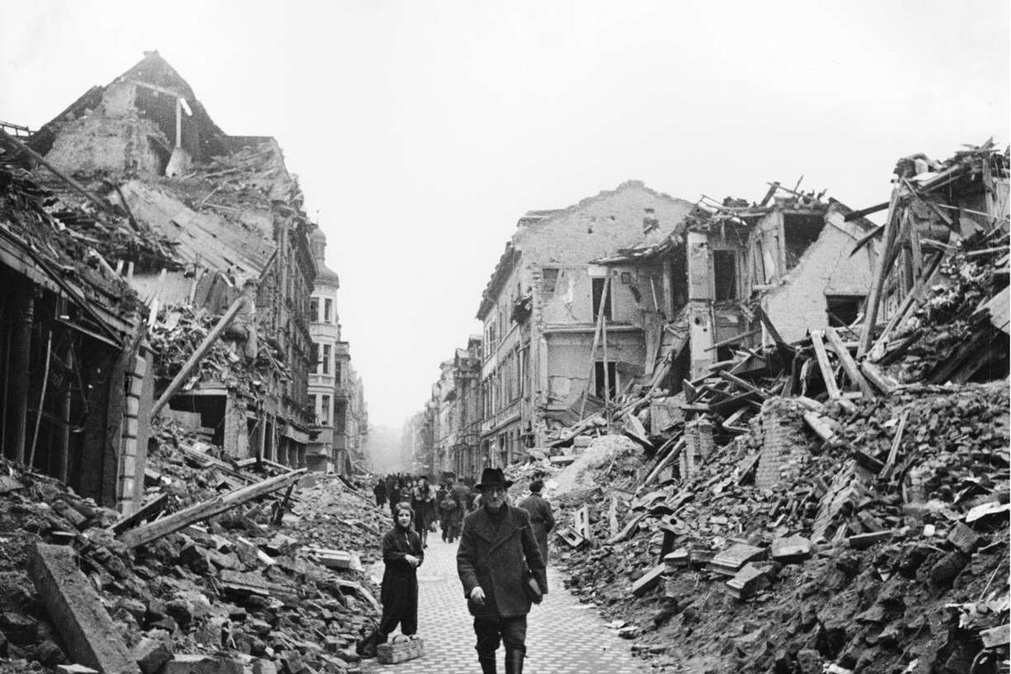 Menschen laufen durch eine von Trümmern gesäumte Straße in Wiesbaden