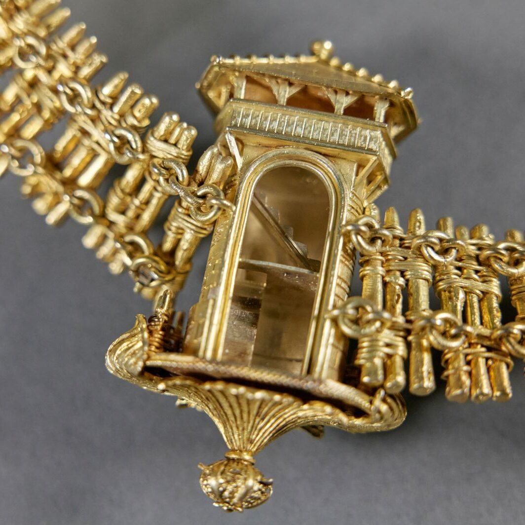 Detail einer vergoldeten Kette mit offenem Limes-Wachturm mit Treppenaufgang