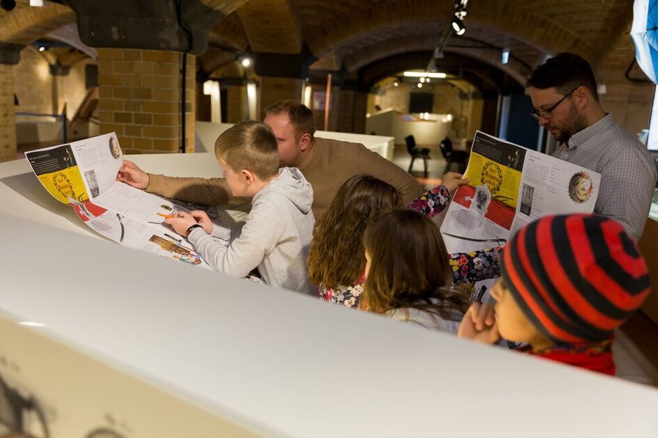 Lehrer und Schüler bearbeiten die Rallyekarte im Museum