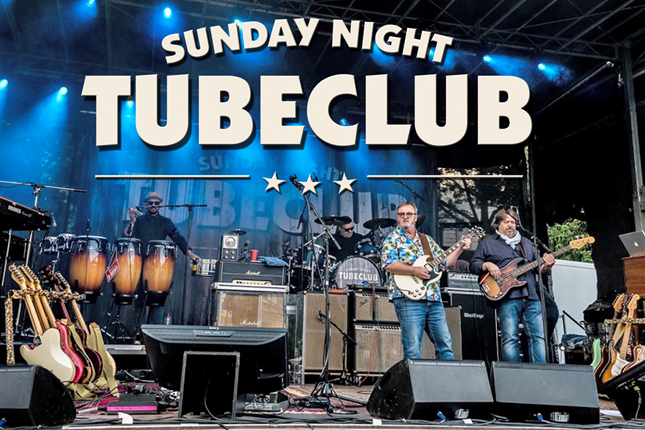 Sunday Night Tubeclub steht auf der Bühne und macht Musik. Es steht dabei sehr viel unterschiedliches auf der Bühne.