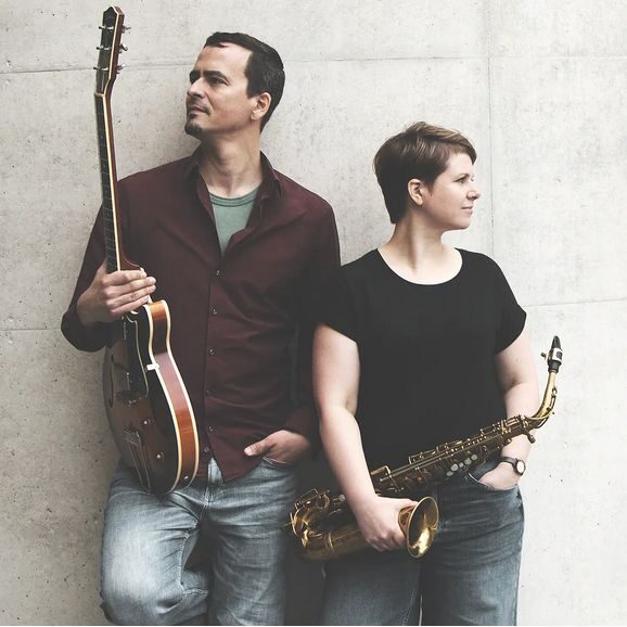 Man with guitar, woman with saxophone