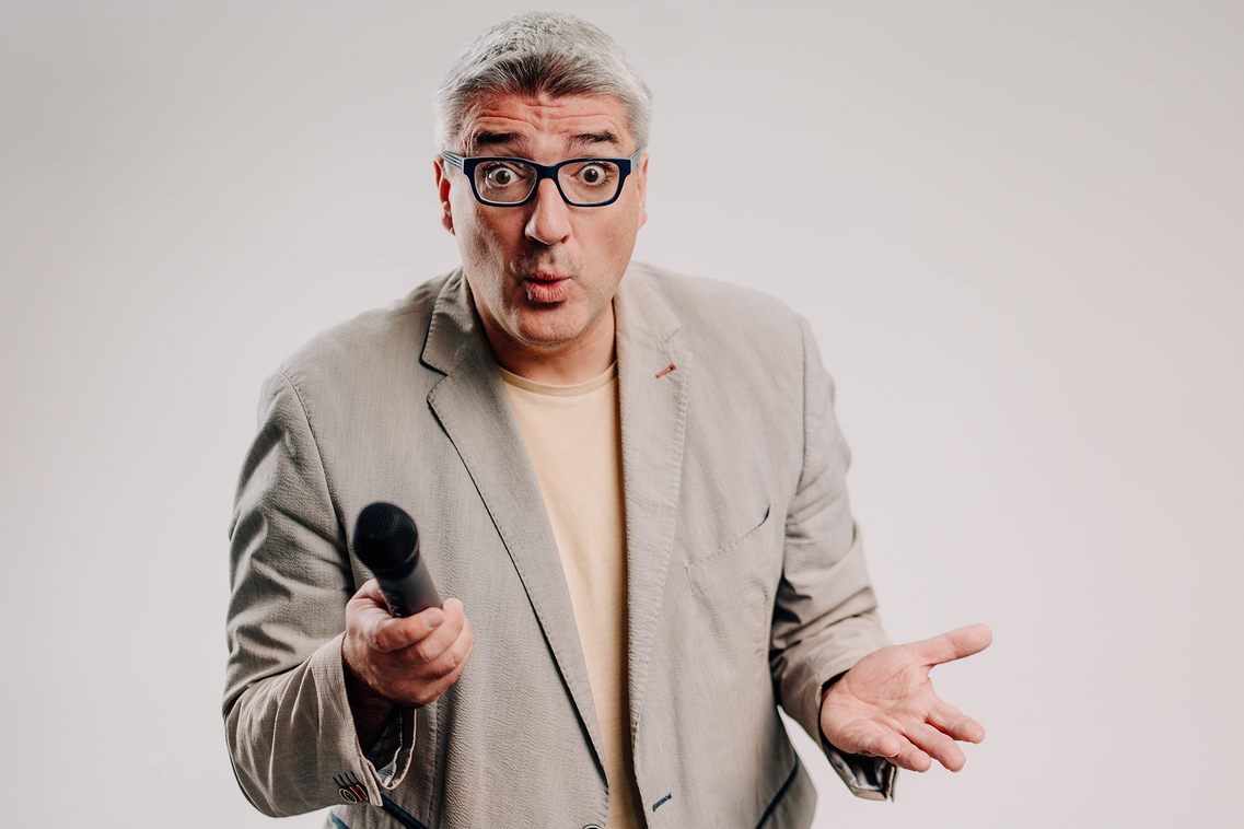 Man mit kurzen, grauen Haaren sowie mit Brille und Anzug.