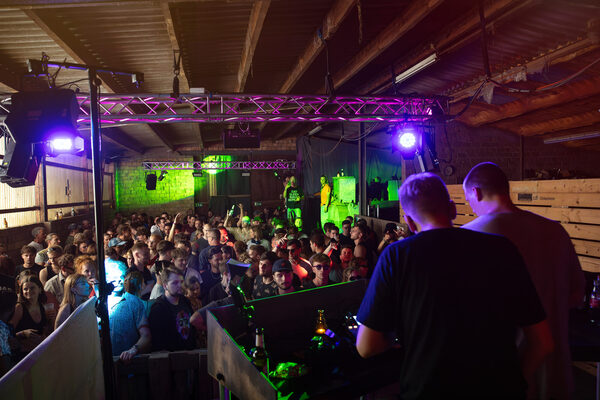 Tanzende junge Erwachsene vor dem erhöhten DJ-Pult bei Rave-Veranstaltung Kulturtage Nordenstadt 2024