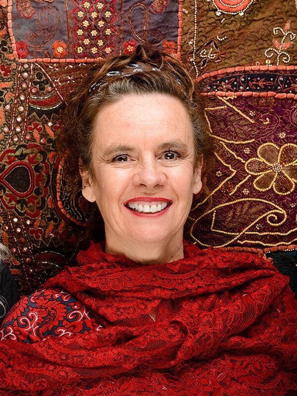 Frau liegt lächelnd auf Teppich
