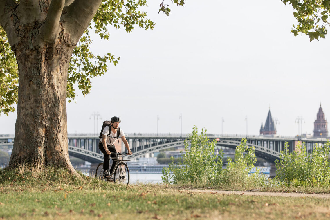 Mann mit Fahrrad vor Brücke Kastel