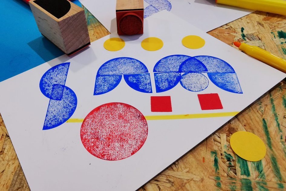 Ein Foto von einem Blatt Papier, auf dem in bunten Farben Formen gestempelt wurden.