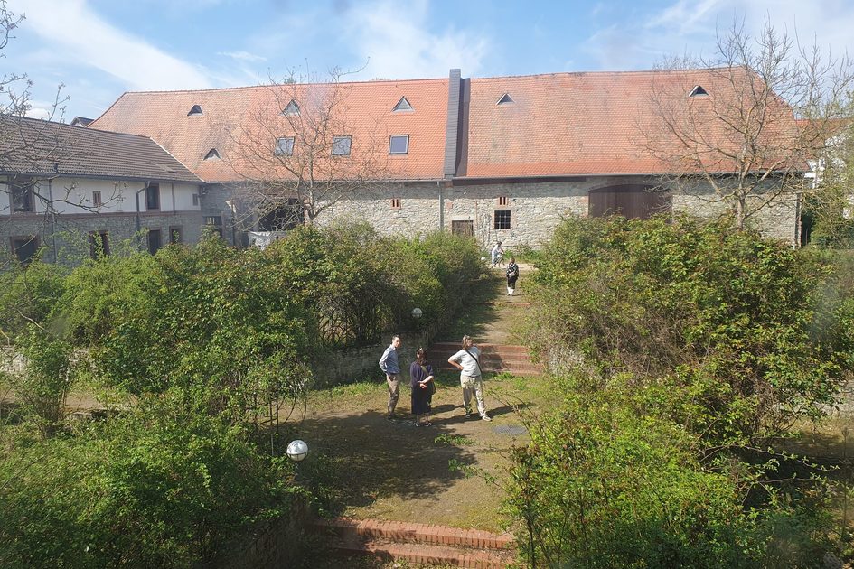 Ein Bild von Menschen im Garten eines Hofgutes.