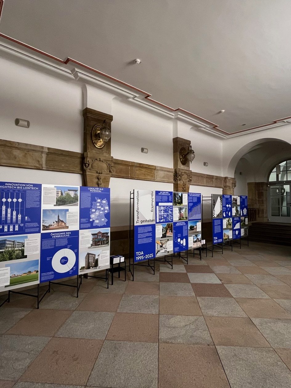 Ein Bild von einem Raum im dem auf Stellwänden eine Ausstellung gezeigt wird.