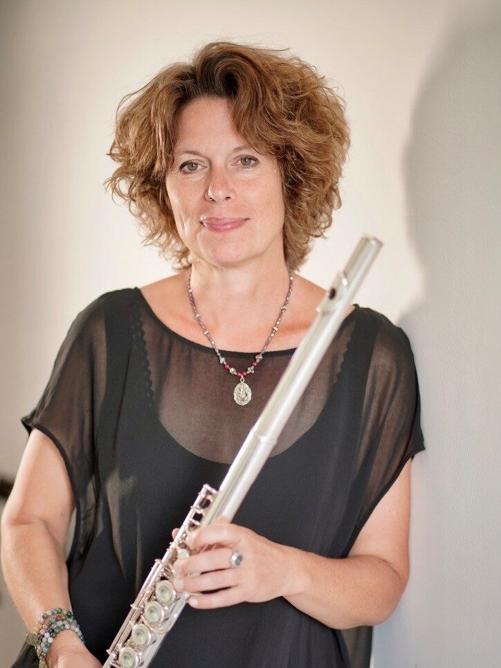 Portrait photo of a woman with curly hair and flute