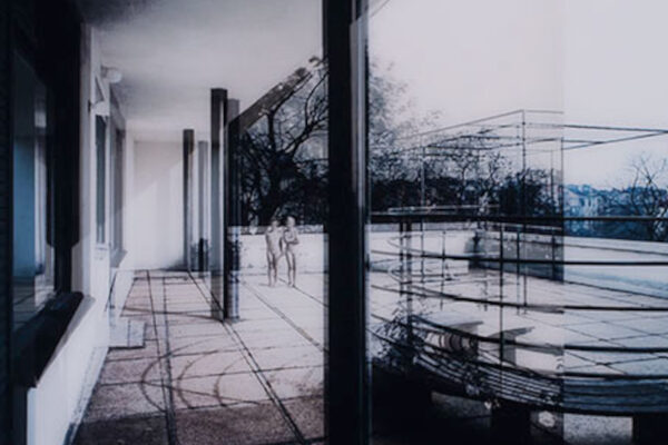 Eine Fotografie von Dirk Brömmel, das zwei unbekleidete Personen auf der Terrasse eines Hauses zeigt.