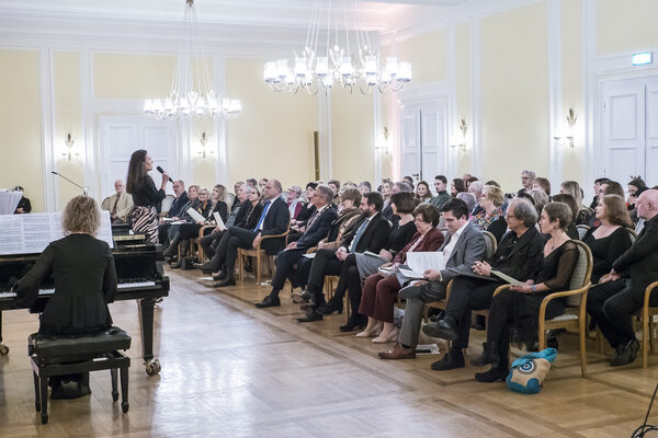 sitzendes Publikum vor Sängerin und Pianisten
