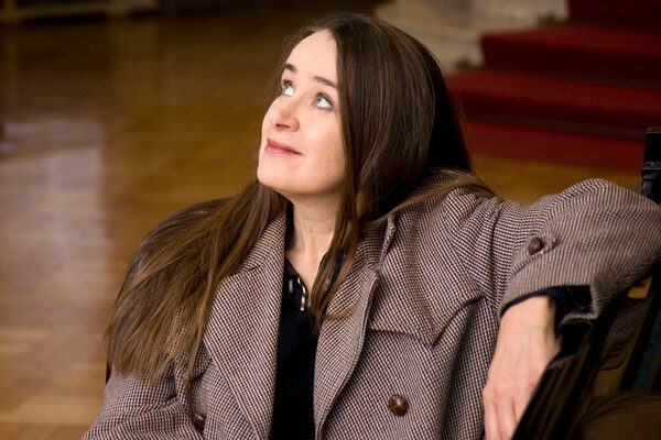 Frau mit dunklen Haaren und kariertem Mantel