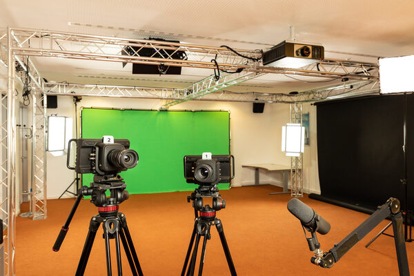 Raum mit Green-Screen, Kameras und einem Mikrophon auf Stativen