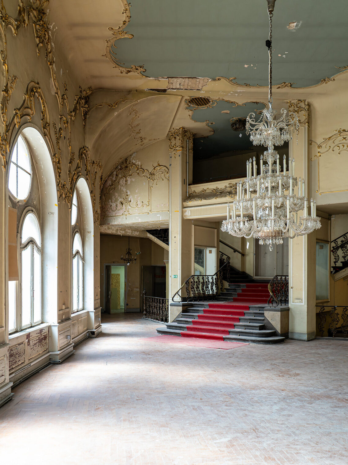 Historisches Gebäude innen, Treppenaufgang mit Leuchter.