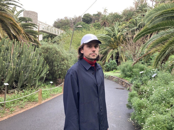 Leif Randt - junger Mann mit langen Haaren und Kappe im botanischen Garten