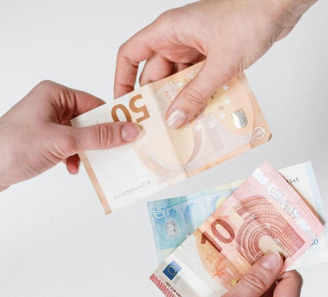Händen reichen sich Geldscheine