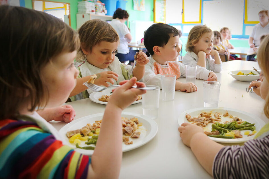 Das Bild zeigt eine Gruppe von Kindern beim Mittagessen.