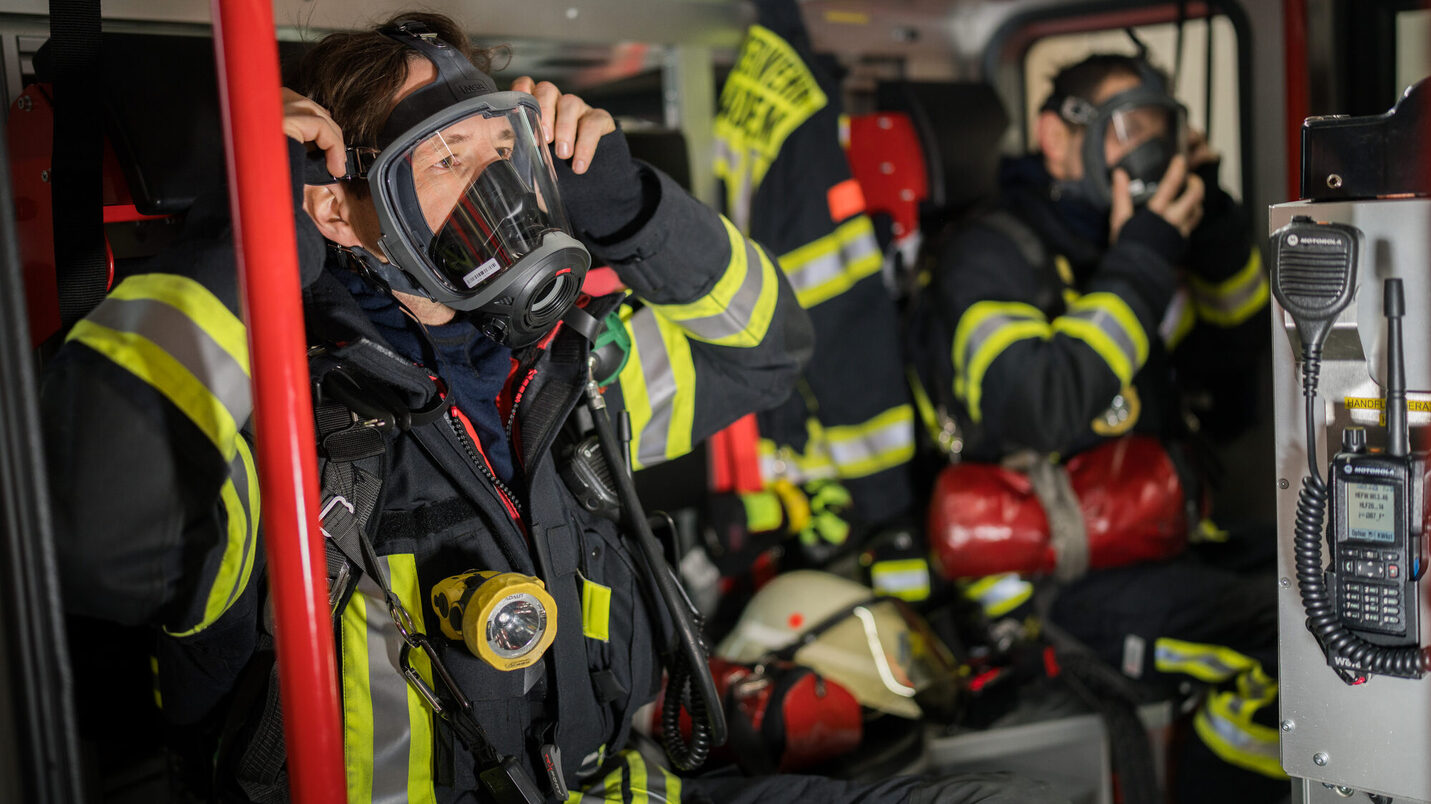 Berufsfeuerwehrmänner beim Ausrüsten im HLF
