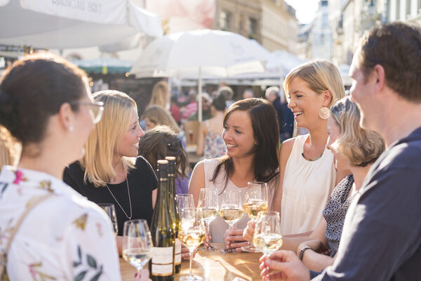 Gruppe junger Menschen um Tisch mit Gläsern