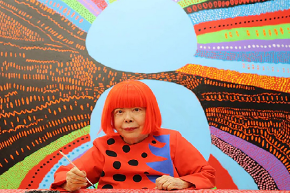 Asiatischer Mensch malt vor buntem Kunstwerk.