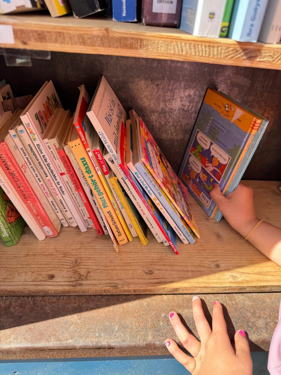 Kind, welches ein Buch aus dem Schrank holt