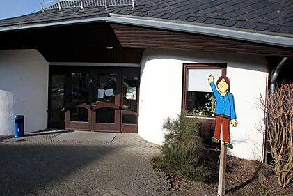 Бяла къща с тъмни прозорци.