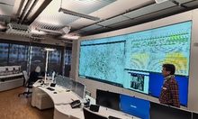 Raum mit großen Monitoren mit Karten an der Wand