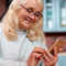 Ältere Frau bedient lächelnd ihr Smartphone