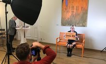 Foto-Shooting: Frau auf Stuhl mit Schild