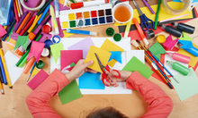 Ferienbetreuung: Kinderhände beim Basteln und Malen.