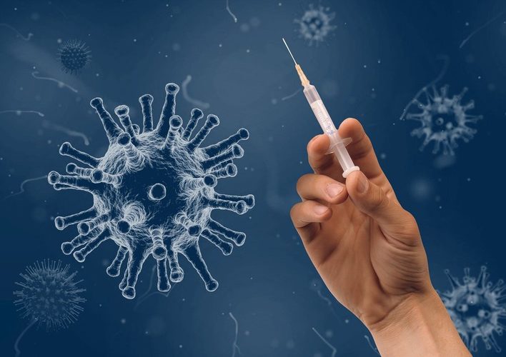 Corona-Schutzimpfungen - Ein symbolisiertes Virus und eine Hand mit Impfun