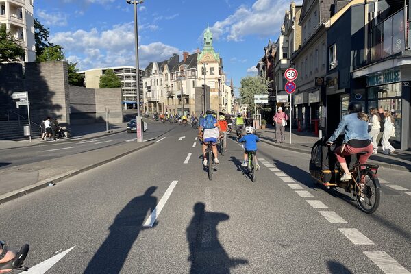 Large group of cyclists riding through Wiesbaden in the sunshine.